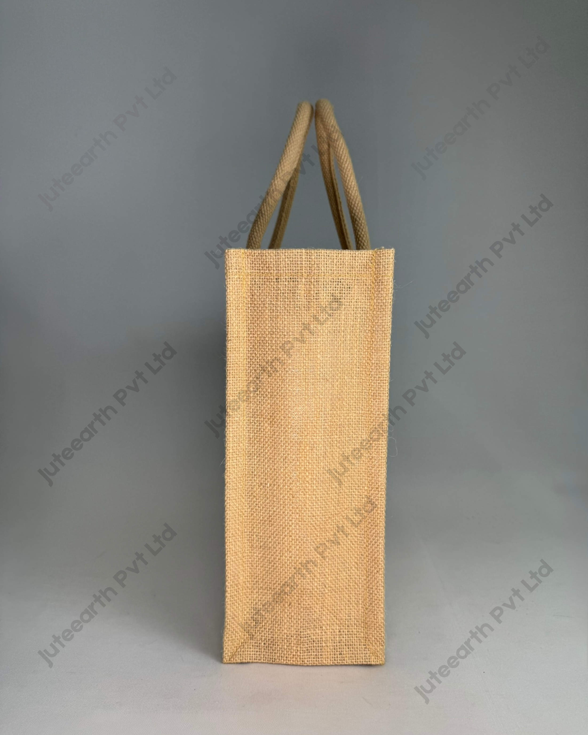 Plain half-white jute bag with jute-colour rope handles, landscape shape, side view showing the gusset