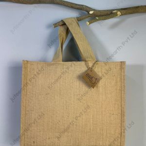 Plain natural jute bag with starch finish and white cotton handles, landscape shape, front view