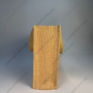 Plain natural jute bag with starch finish and white cotton handles, landscape shape, side view showing the gusset
